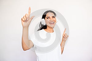 Portrait of happy young woman listening to music and dancing