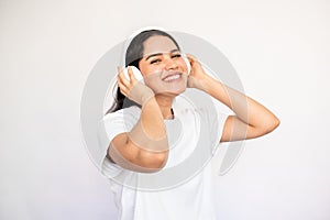 Portrait of happy young woman listening to music in headphones