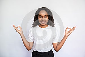Portrait of happy young woman meditating over white background