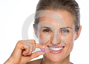 Portrait of happy young woman with pill