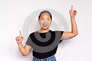 Portrait of happy young woman pointing upwards