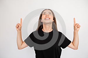 Portrait of happy young woman pointing upwards