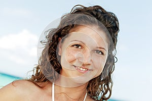 Portrait of a happy young woman posing while on the beach