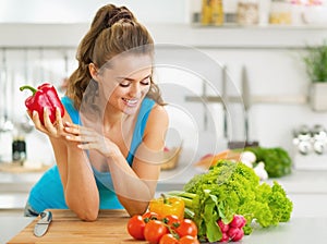 Portrait of happy young woman ready to make vegetable salad