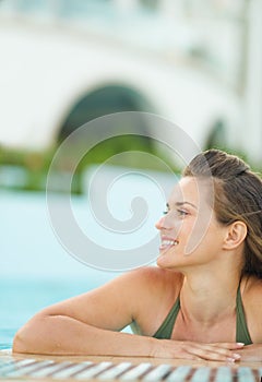 Portrait of happy young woman relaxing in pool