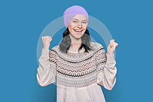 Portrait of happy young woman in sweater hat celebrating winter holidays