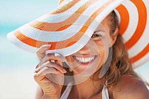 Portrait of happy young woman in swimsuit and beach hat