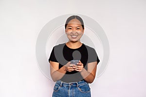 Portrait of happy young woman texting message on mobile phone