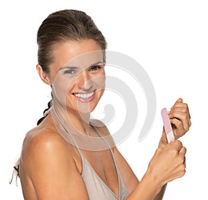 Portrait of happy young woman using nail file