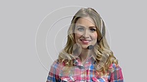 Portrait of happy young woman wearing headset and talking.