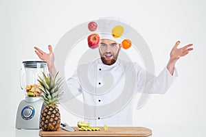 Portrait of a hapy male chef cook juggle with fruits