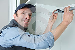 portrait hapy man during fitted kitchen cabinet installation