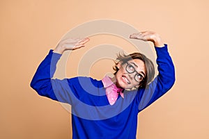 Portrait of hardworking agent lady look up hands palms hold resist empty space isolated on beige color background