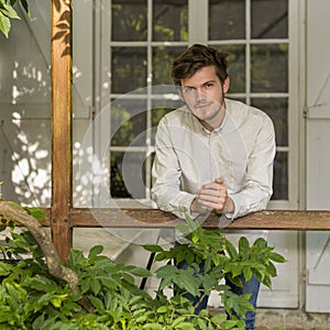 Portrait head and shoulders of bearded young man standing outdoors