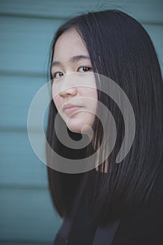 Portrait headshot of asian teenager looking with eyes contact to camera