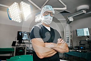 Portrait, healthcare and arms crossed by man doctor in operating room with confidence in medical, surgery or emergency