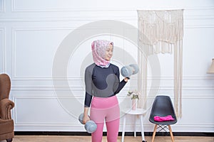 Portrait of healthy asian woman with hijab doing exercise at home