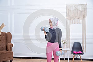 Portrait of healthy asian woman with hijab doing exercise at home