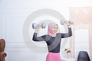 Portrait of healthy asian woman with hijab doing exercise at home