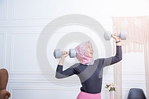 Portrait of healthy asian woman with hijab doing exercise at home