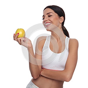 Portrait of healthy beautiful woman holding and looking at apple