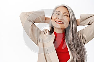 Portrait of healthy and happy asian senior woman, middle aged korean lady with long grey hair, laughing and smiling