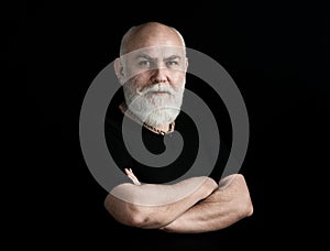 Portrait of healthy happy senior elderly caucasian old man face with arm crossed isolated on black. Golden age grand