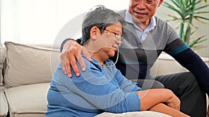 Portrait of healthy senior man and woman embracing and sitting on sofa at home, Happy senior married couple spending