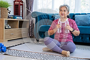 Portrait healthy senior woman exercise use bottles instead of dumbbells