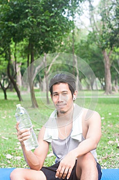 Portrait of healthy young man holding bottle of water