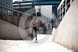 Portrait of a healthy young woman running outdoors.