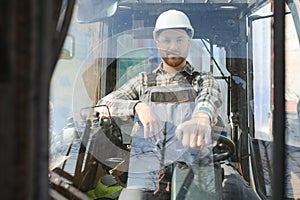 Portrait of heavy industry forklift driver giving thumbs up and smiling