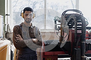 Portrait of heavy industry worker with safety headphones and in industrial factory
