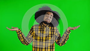 Portrait of helpless african american man throwing hands aside and shrugging dont know or cant help on green screen or