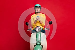 Portrait of her she nice attractive lovely cheerful cheery girl sitting on moped using cell internet online wi-fi 5g
