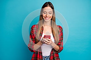 Portrait of her she nice attractive lovely focused cheerful cheery long-haired girl wearing checked shirt texting