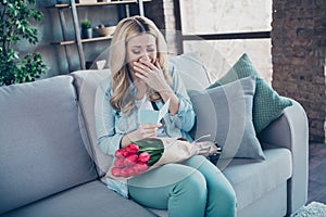 Portrait of her she nice attractive pretty cheerful cheery wavy-haired girl sitting on divan reading sweet post card