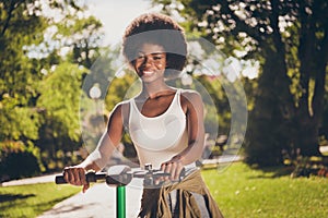 Portrait of her she nice-looking attractive pretty lovely cheerful cheery girl riding kick scooter bike spending free