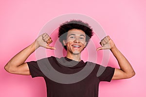 Portrait of heroic egocentric young man in brown t shirt indicating fingers himself pick me best choice isolated on pink