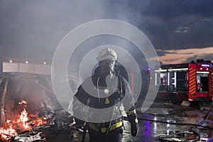 Portrait of a heroic fireman in a protective suit. Firefighter in fire fighting operation.