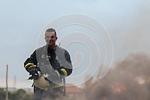 Portrait of a heroic fireman in a protective suit. Firefighter in fire fighting operation.