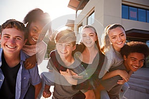 Portrait Of High School Students Giving Each Other Piggybacks College Buildings