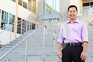 Portrait Of High School Teacher Standing Outside Building