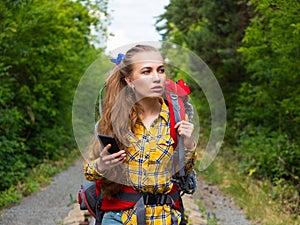 Portrait of a woman, who lost in forest. She using mobile GPS map.