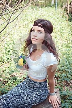 Portrait of hippie girl in forest with flowers