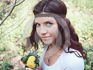 Portrait of hippie girl in forest with flowers