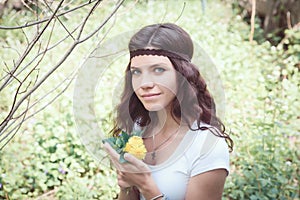 Portrait of hippie girl in forest with flowers