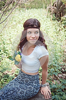 Portrait of hippie girl in forest with flowers