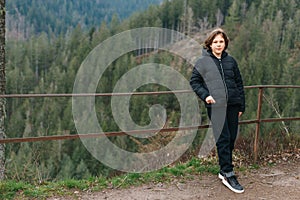 Portrait of a hipster young cute attractive girl traveler travelling in a mountain valley. Happy girl, tourist posing on