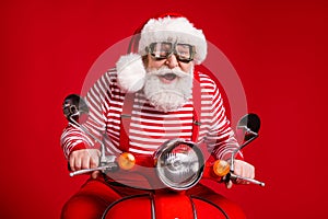 Portrait of his he handsome cheerful cheery bearded Santa father riding moped delivering gifts journey fast speed having